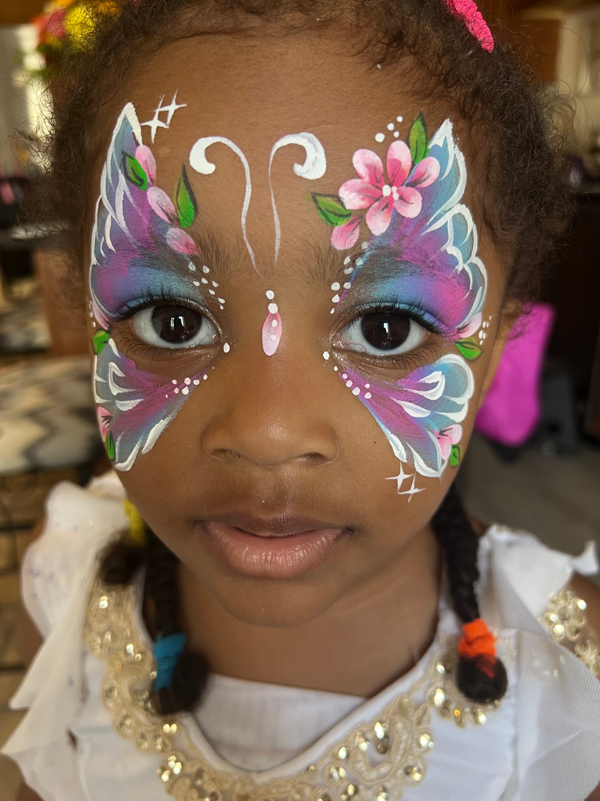 Close-up of a butterfly-wing face painting design around a child's eyes