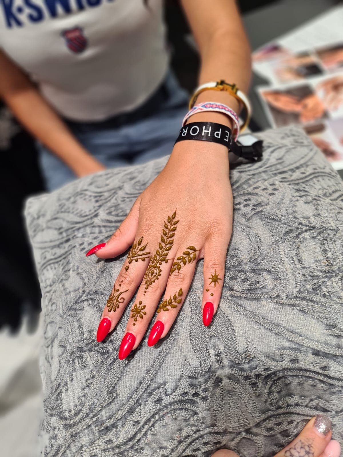 Gold henna leaf and star designs on fingers