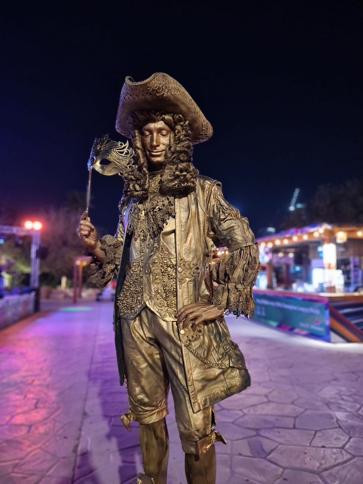Portrait of a gold-painted living statue performer in pirate costume